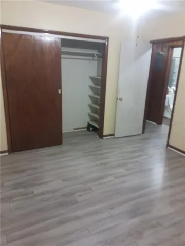 an empty room with wooden floor and closet