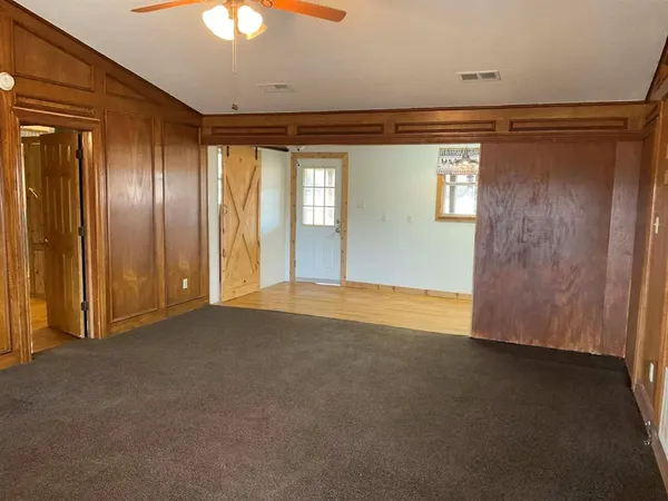 a view of empty room with window and ceiling fan