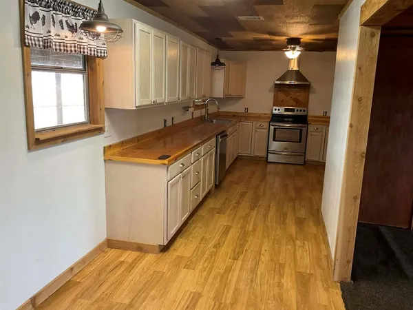 a kitchen with a sink a stove and cabinets