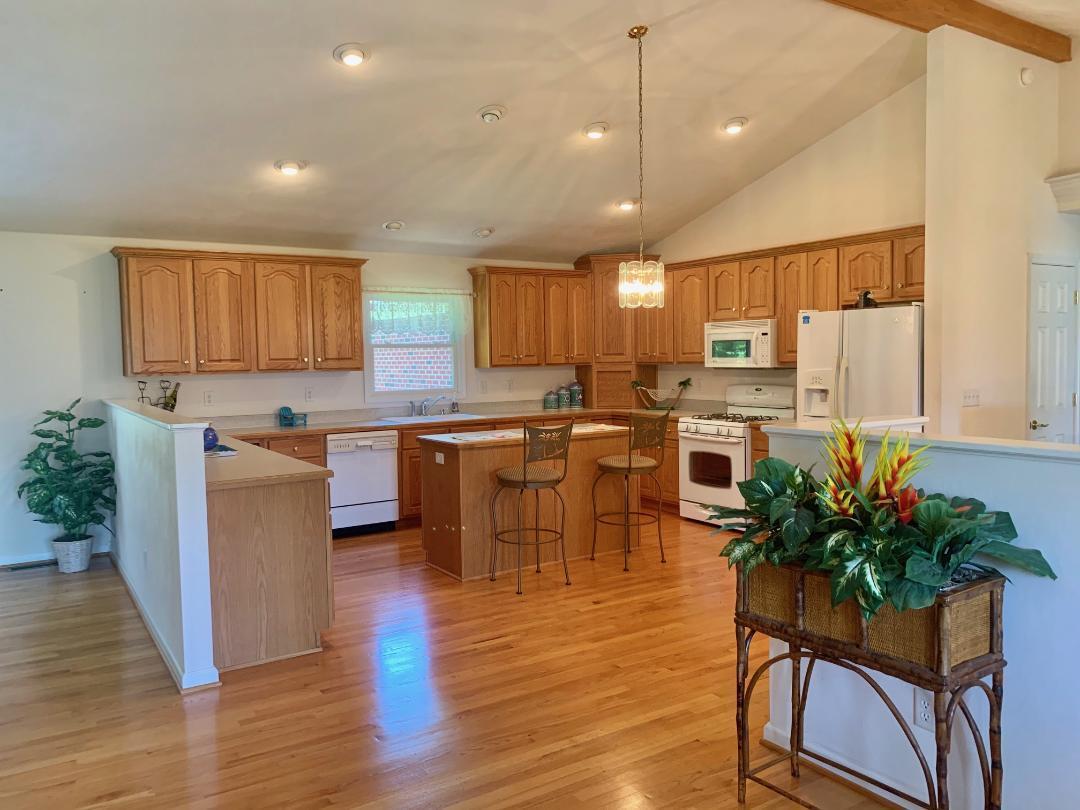 525 Mallard Point Road Wirtz, VA 24184 - Photo 10 of 38 a kitchen with stainless steel appliances kitchen island granite countertop a table chairs and a refrigerator