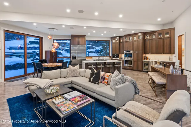 a living room with furniture kitchen view and a large window