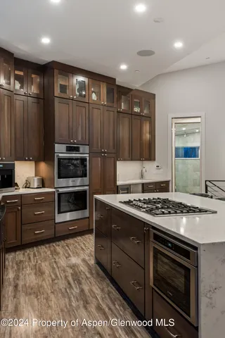 a kitchen with stainless steel appliances kitchen island granite countertop a stove and a sink