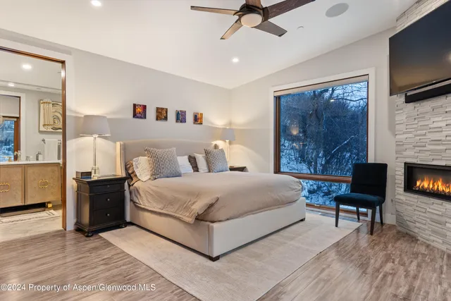 a spacious bedroom with a bed and a television