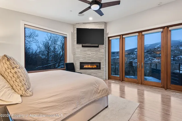 a spacious bedroom with a balcony a bed and a flat screen tv