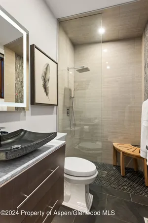 a bathroom with a toilet a sink and glass door