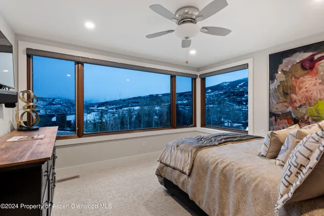 a bed sitting in a spacious bedroom next to a window