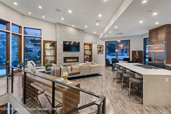 a large kitchen with stainless steel appliances a stove a sink a dining table and chairs