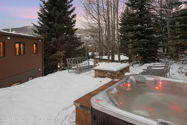 a roof deck with table and chairs under an umbrella