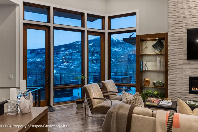 a living room with furniture a rug and a floor to ceiling window