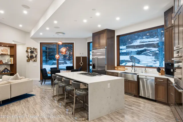 a kitchen with stainless steel appliances a sink a stove a refrigerator and cabinets