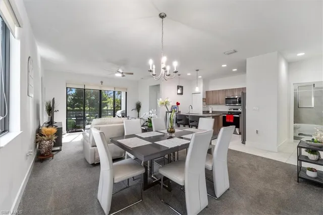 a dining room with furniture a chandelier and window