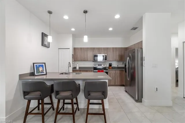 a kitchen with refrigerator and chairs