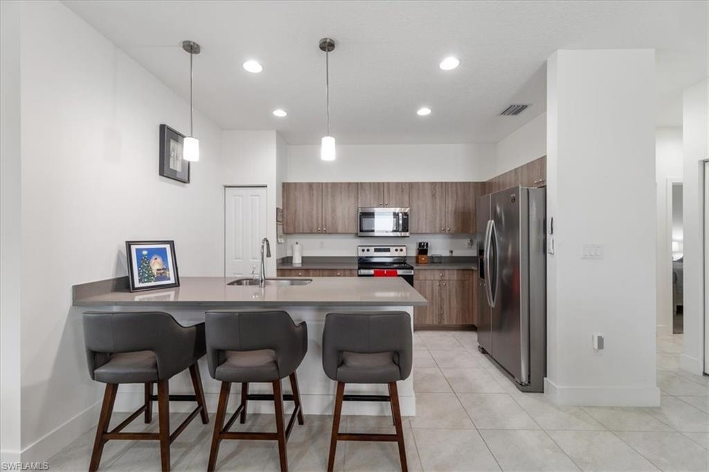 4925 Gambero Way Avenue Immokalee, FL 34142 - Photo 16 of 50 a kitchen with refrigerator and chairs