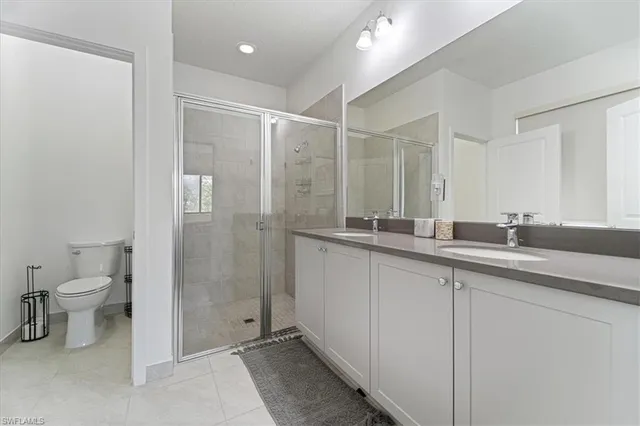 a bathroom with a double vanity sink mirror and toilet