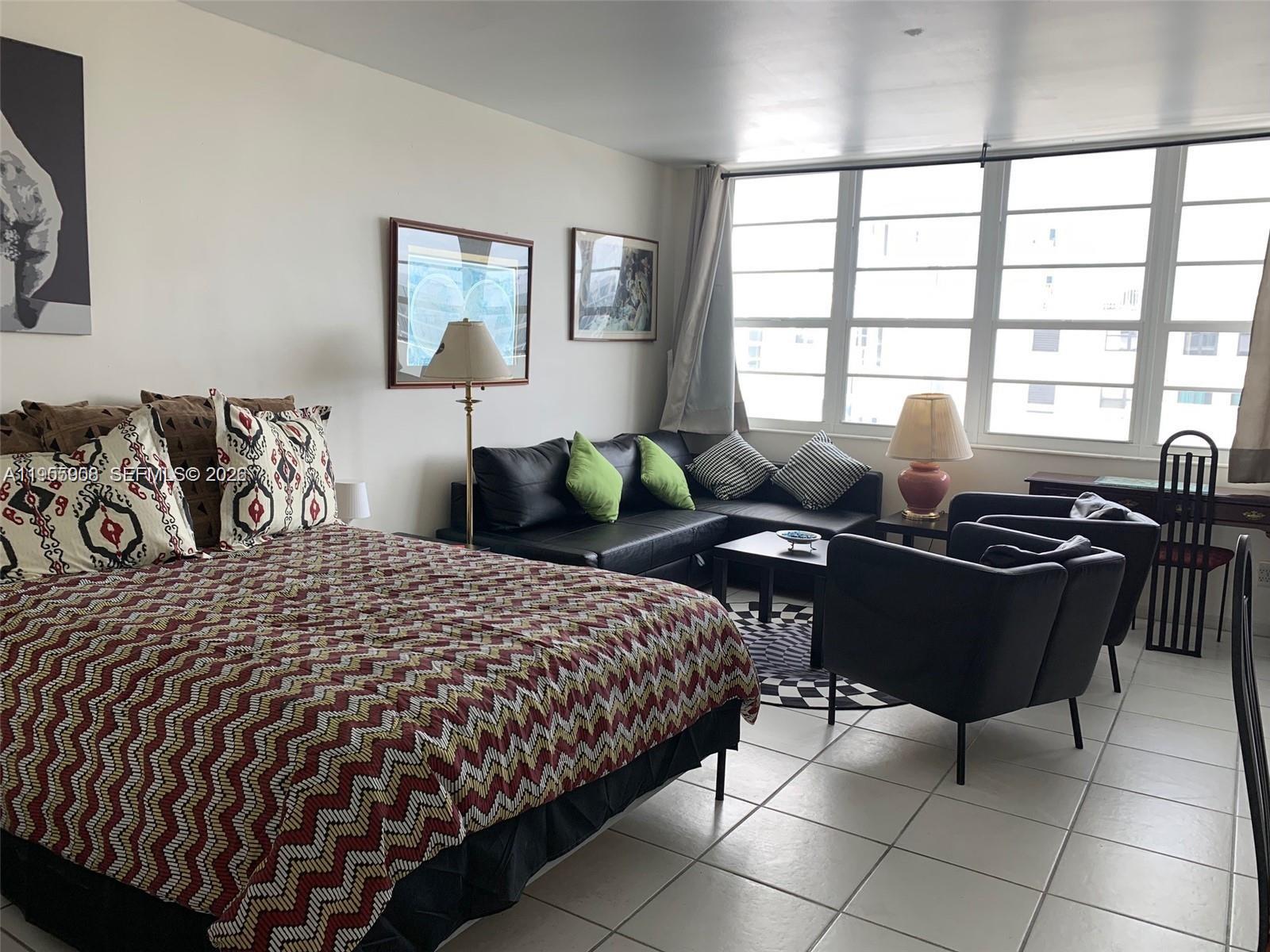 100 Lincoln Road, Unit 903 Miami Beach, FL 33139 - Photo 3 of 17 a bedroom with a bed and a lamp