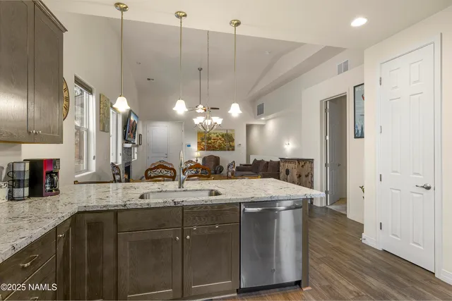 a bathroom with a granite countertop sink a light fixture and a mirror