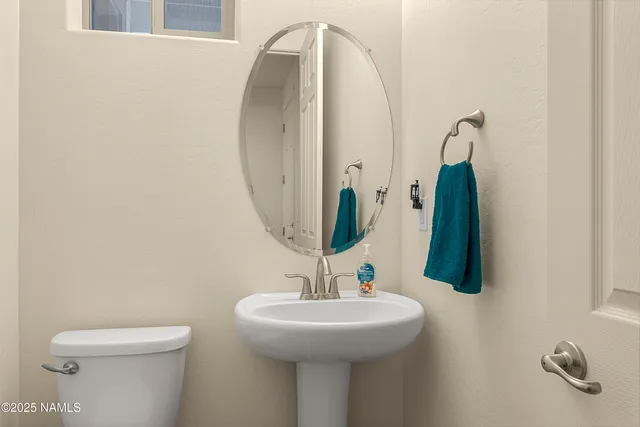 a bathroom with a sink a toilet and a mirror