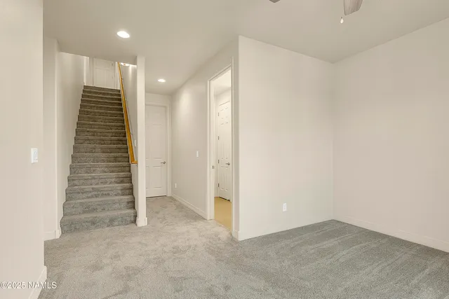 an empty room with a hallway and stairs