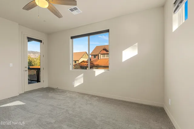 an empty room with closet and a chandelier fan