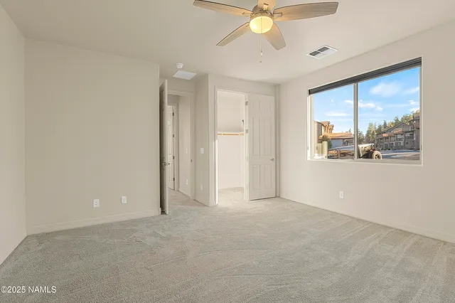 an empty room with fan and windows