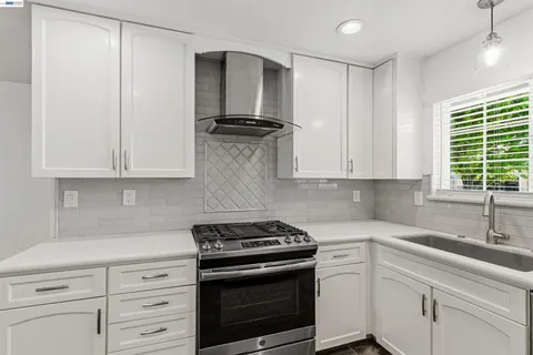 a kitchen with granite countertop white cabinets and white appliances