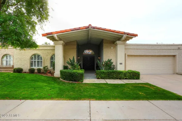 a front view of a house with a garden and plants