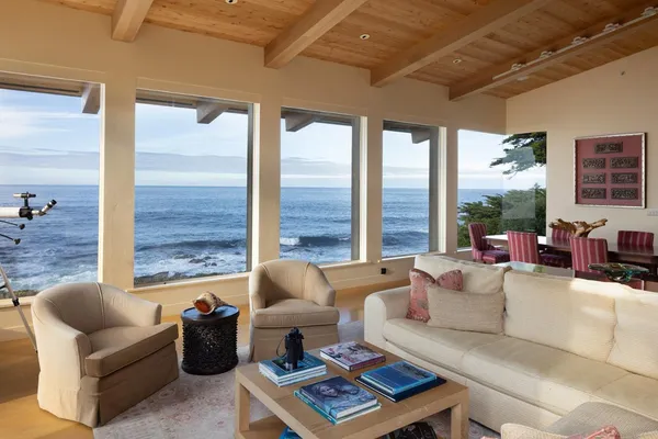 a living room with furniture and floor to ceiling windows
