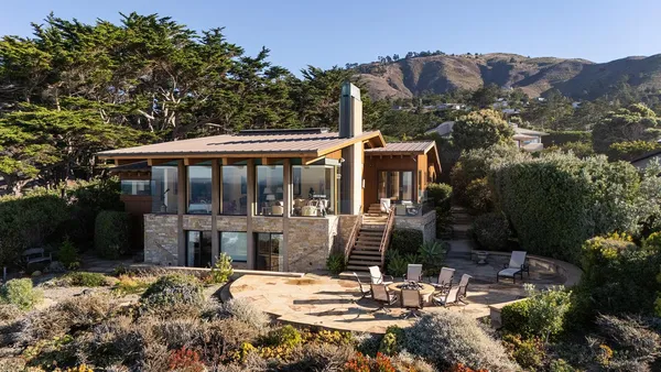 a view of a patio with table and chairs and potted plants with large tree