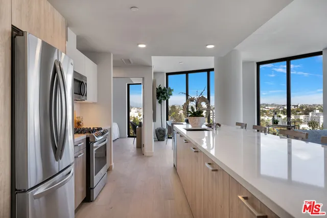 a kitchen with stainless steel appliances a refrigerator sink and stove