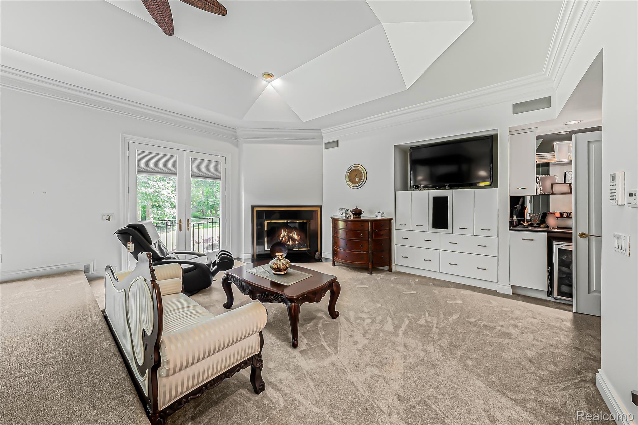 2785 Cranbrook Ridge Court Rochester, MI 48306 - Photo 34 of 99 Vaulted ceiling with crown molding, double French doors, built-in entertainment center, corner fireplace, and a wet bar with integrated beverage cooler