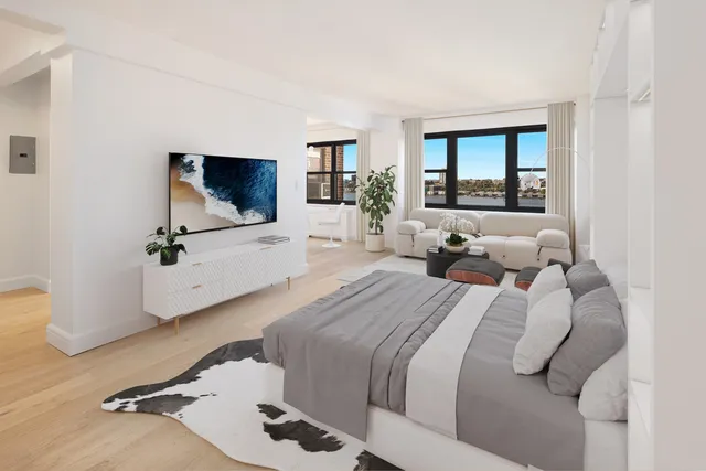 a living room with furniture a flat screen tv and kitchen view