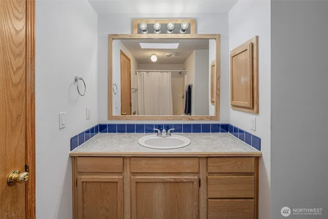 a bathroom with a granite countertop sink and a mirror