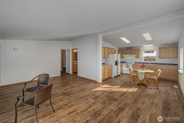 a living room with furniture a kitchen view and a dining table