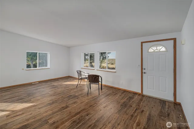 a view of a livingroom with wooden floor and a workspace