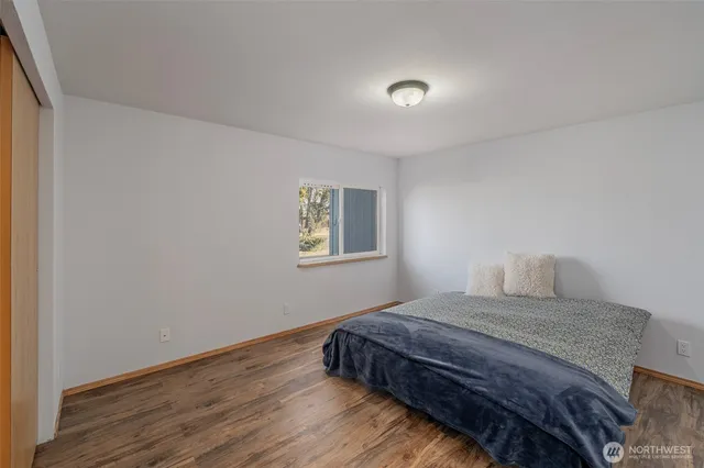 a bedroom with a bed and wooden floor