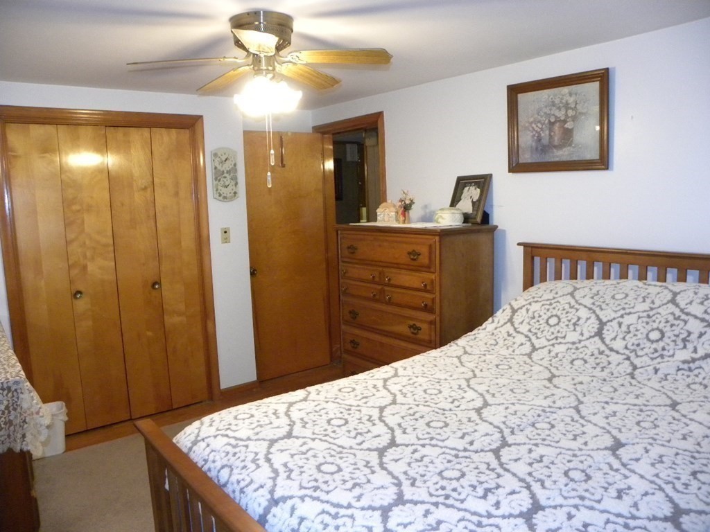 8 Everett Avenue Webster, MA 01570 - Photo 24 of 29 a bedroom with a bed and a chandelier