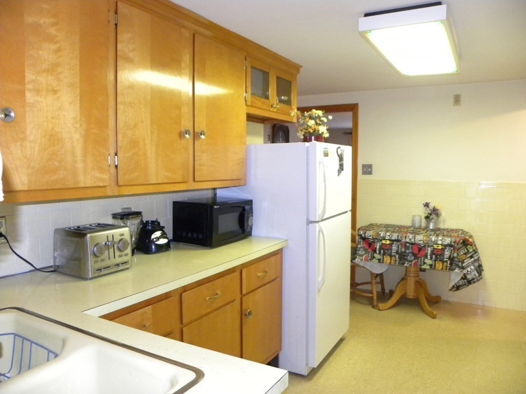 8 Everett Avenue Webster, MA 01570 - Photo 7 of 29 a kitchen with a refrigerator and a sink