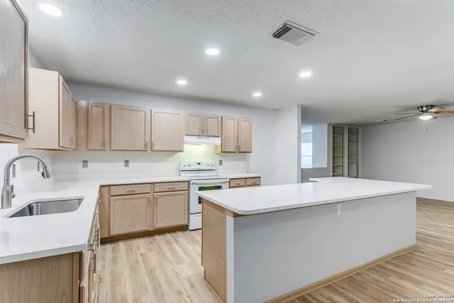 a kitchen with a sink a stove and cabinets