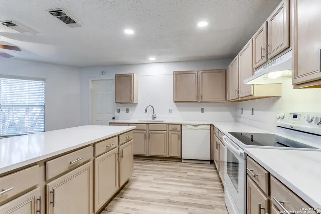 a kitchen with a sink stove and cabinets