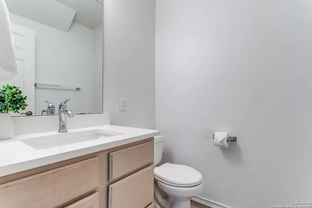 a bathroom with a sink toilet and a mirror