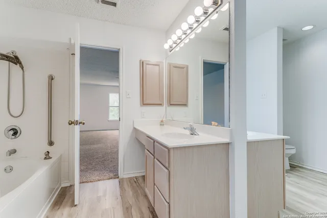 a bathroom with a sink double vanity mirror and a bathtub
