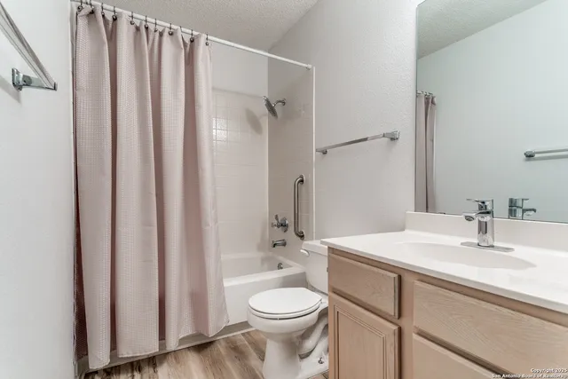 a bathroom with a granite countertop sink toilet and shower