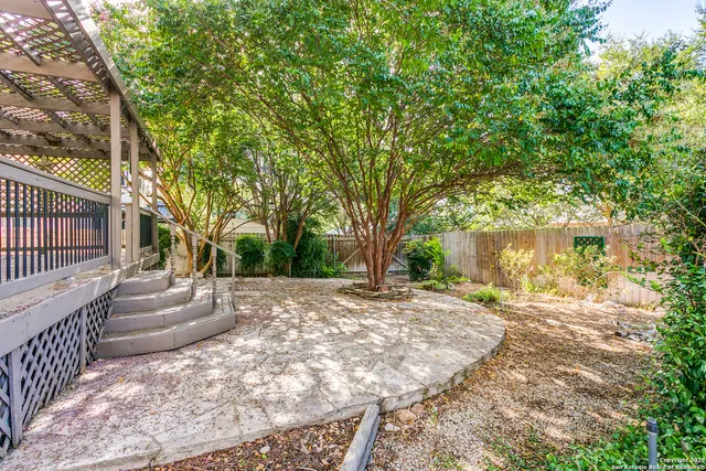 a front view of a house with a yard and tree s