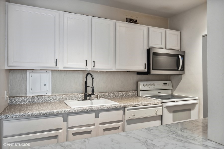 535 North Michigan Avenue, Unit 2505 Chicago, IL 60611 - Photo 5 of 14 a kitchen with stainless steel appliances granite countertop a sink and a microwave