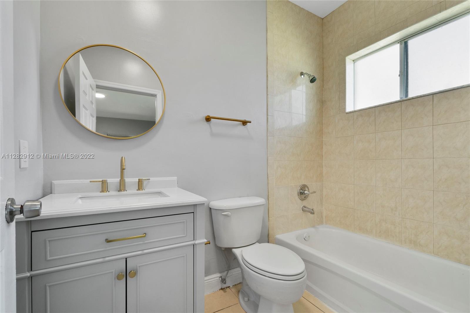 Gladeview Miami, FL 33147 - Photo 19 of 31 a bathroom with a sink a toilet and a mirror