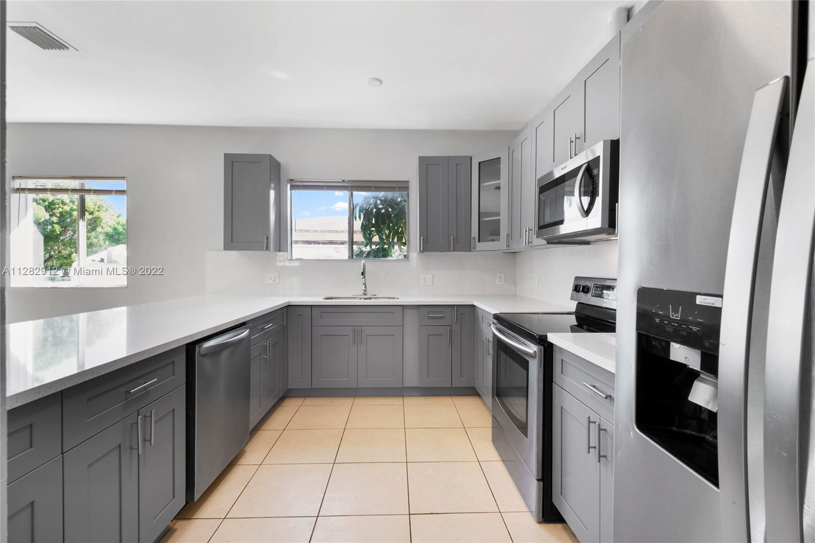 Gladeview Miami, FL 33147 - Photo 7 of 31 a kitchen with stainless steel appliances granite countertop a sink and dishwasher a stove top oven with wooden floor
