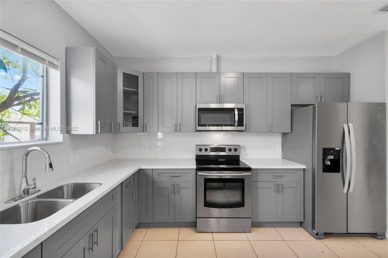 Gladeview Miami, FL 33147 - Photo 9 of 31 a kitchen with stainless steel appliances a stove sink microwave and refrigerator
