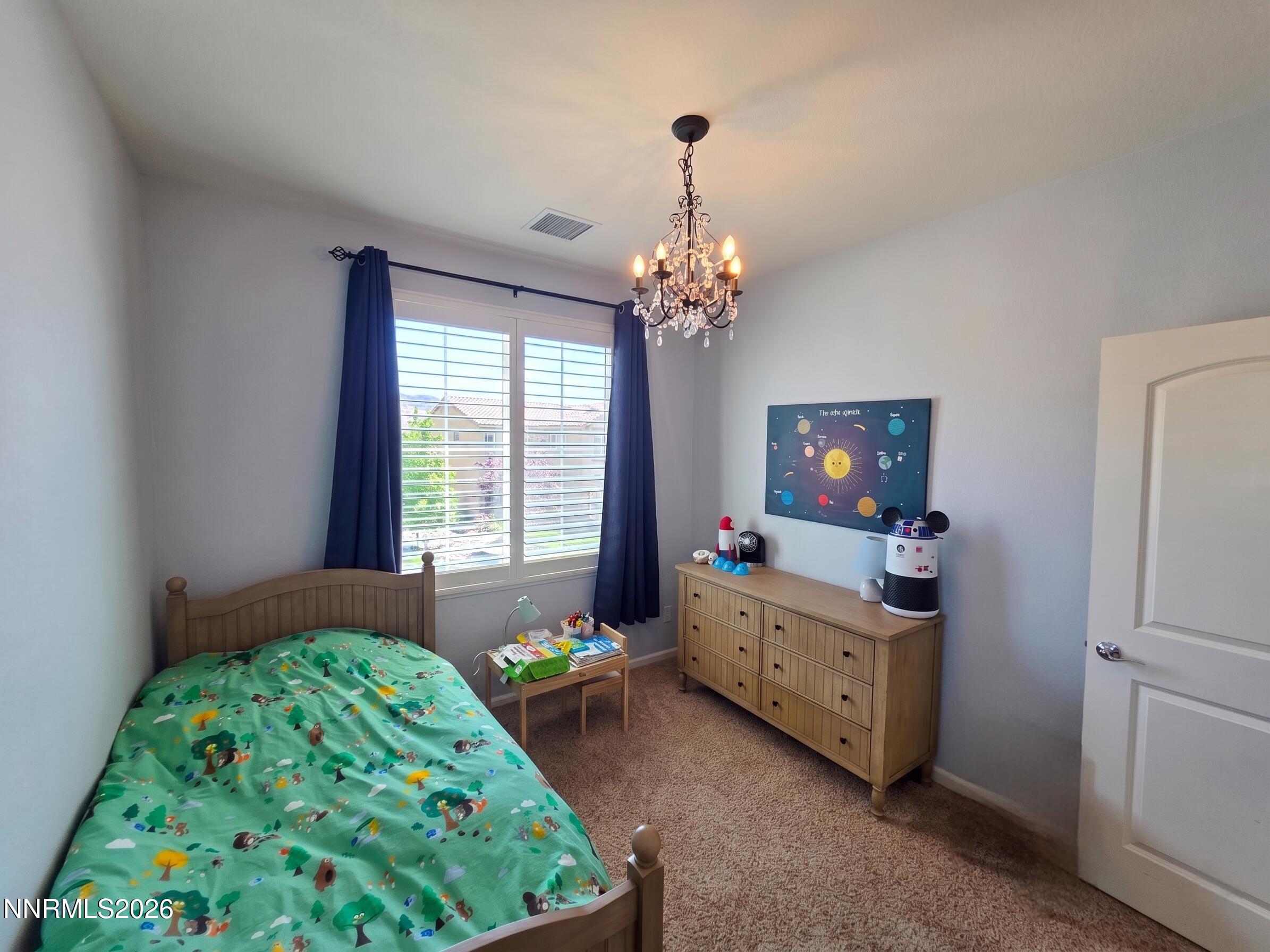 2775 Bonfire Lane Reno, NV 89521 - Photo 31 of 41 a bedroom with a bed and a chandelier