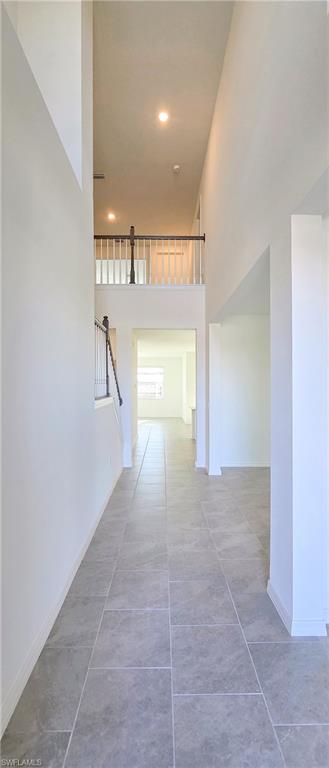 13329 Turnleaf Boulevard Punta Gorda, FL 33955 - Photo 3 of 23 Hall featuring a high ceiling, stairway, recessed lighting, and light tile patterned floors