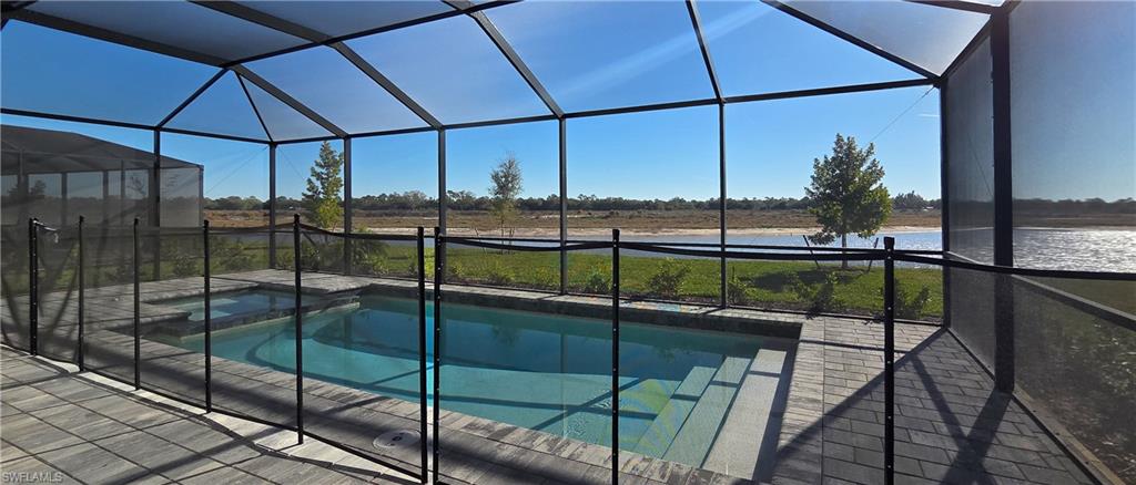 13329 Turnleaf Boulevard Punta Gorda, FL 33955 - Photo 9 of 23 View of pool with glass enclosure, a sunroom, a water view, and a pool with connected hot tub
